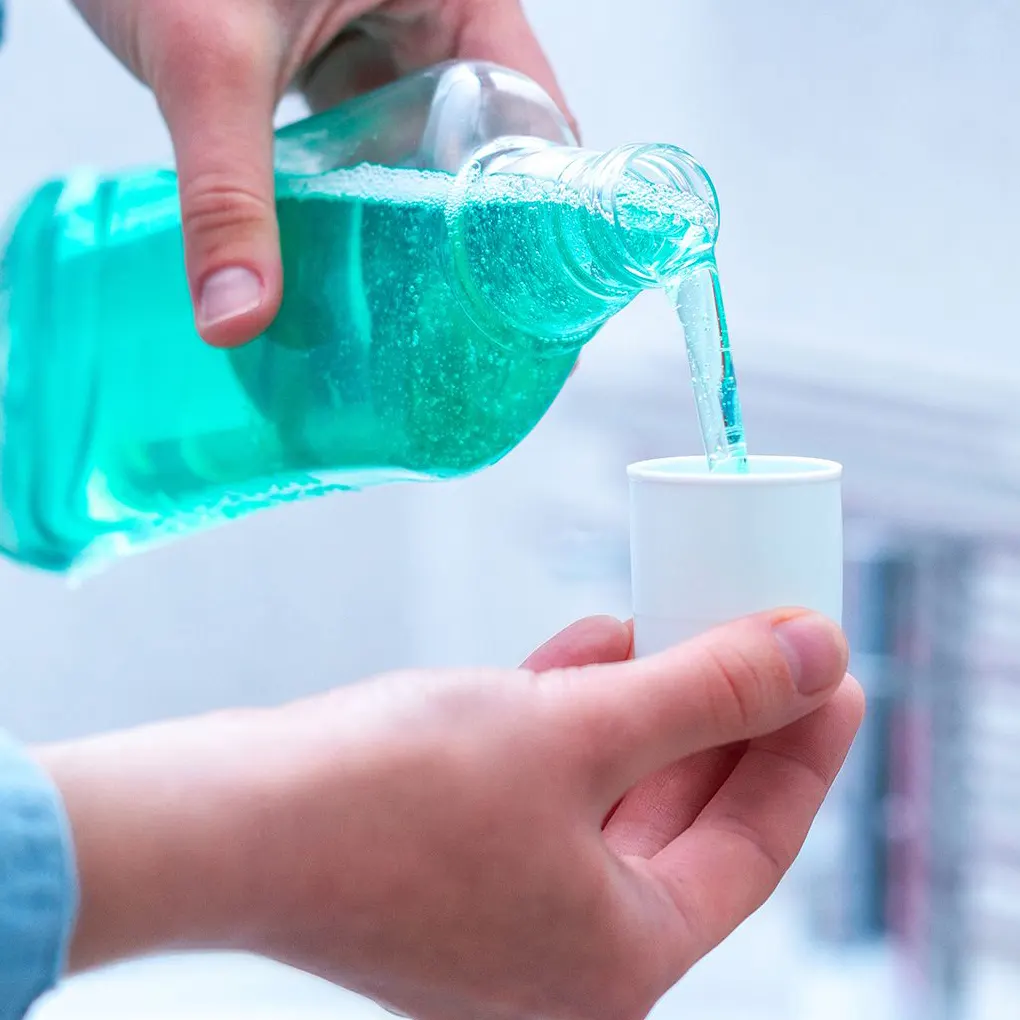 Sử dụng nước súc miệng Chúng ta thường ăn những loại thực phẩm nặng mùi như tỏi, hành cũng là nguyên nhân gây ra hơi thở có mùi hôi. Ngoài ra, việc vệ sinh răng miệng kém khiến thức ăn thừa còn sót lại trên kẽ răng cũng tạo điều kiện cho vi khuẩn phát triển gây hại cho men răng.  Do đó, chúng ta cần sử dụng nước súc miệng để giúp loại bỏ vi khuẩn gây hại và mang lại hơi thở thơm mát. Chúng ta cần lựa chọn loại nước súc miệng có chứa flour phù hợp để ngăn chặn tình trạng sâu răng, viêm nướu và hôi miệng hiệu quả.