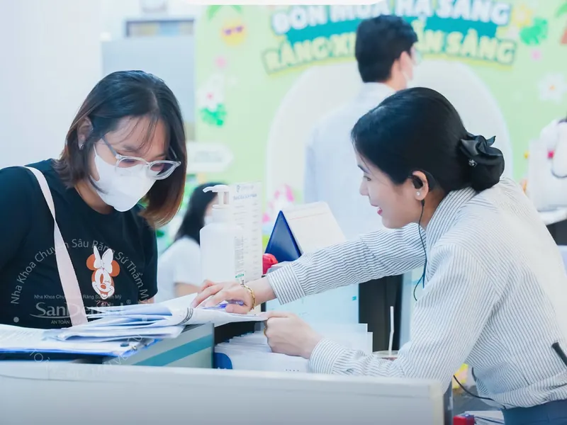Lễ tân San Dentist hỗ trợ khách hàng làm thủ tục thăm khám
